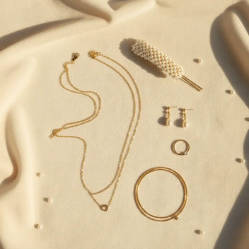 Refined MystiBox jewelry flat lay with gold-tone pieces and pearl accents